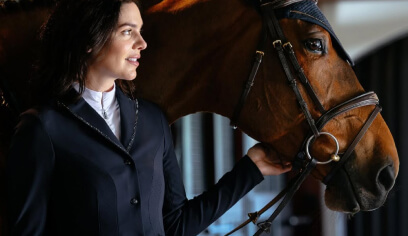Equestrian rider in a dark blazer beside a horse, from LeMieux, an Antavo loyalty customer